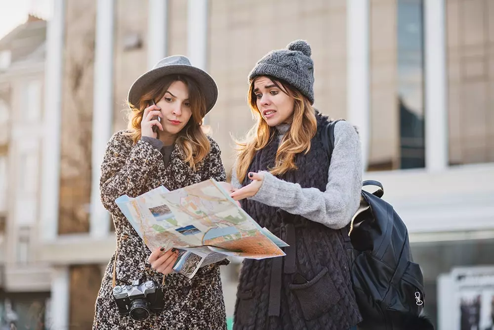two girls walking in city center and looking for direction